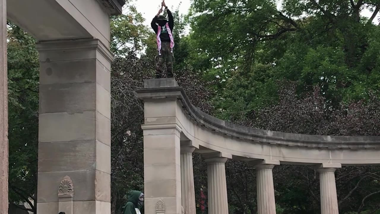 PROTESTER FREE CLIMBS LARGE STRUCTURE