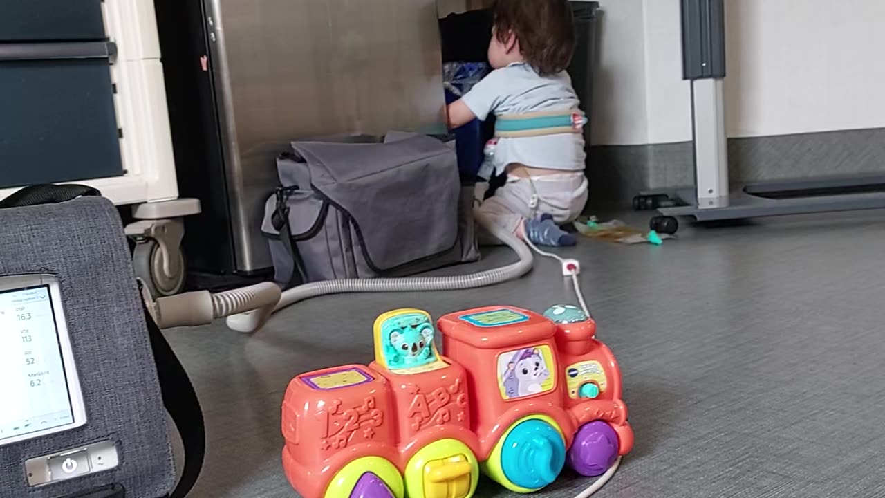 Theo helping with throwing out a dirty diaper into the garbage bin