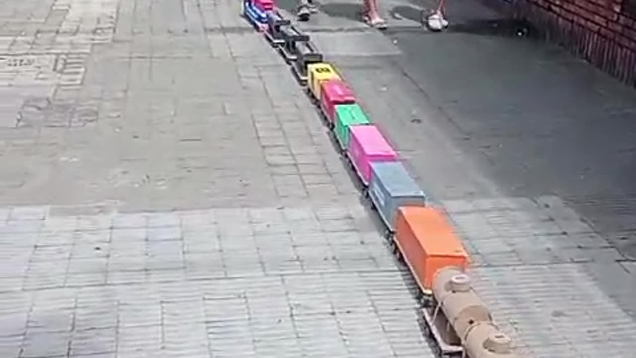 Little Boy Walks Giant Train Down Sidewalk