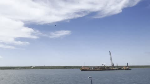 Tug boat getting made up to barge and getting underway