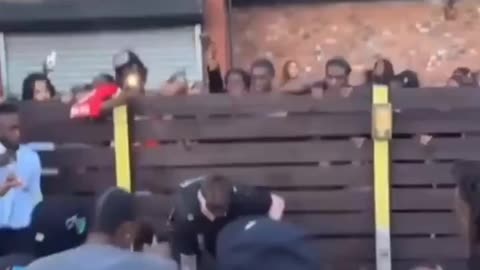 British policeman surrounded by a crowd of black people in Leicester.