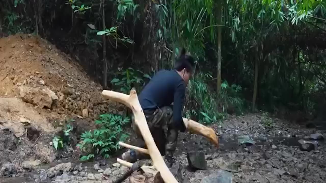 A man builds a cozy house in the forest with his own hands