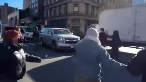 ICE protester literally jumps onto the hood of a moving vehicle using lights & sirens