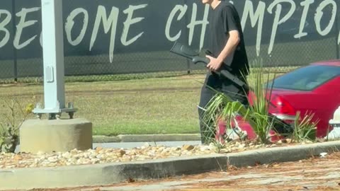 Man Walking Public Street With A Gun