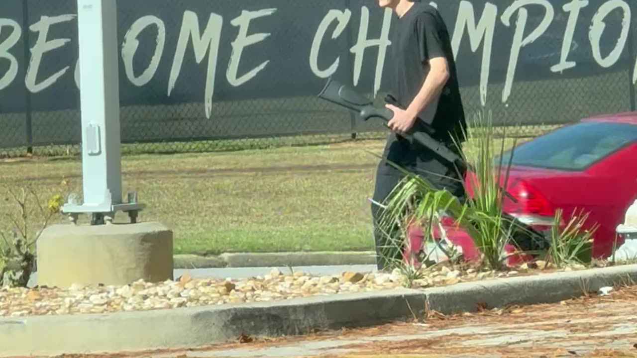Man Walking Public Street With A Gun