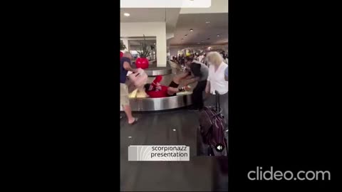 A passenger slips while taking his luggage from the baggage counter at the airport...