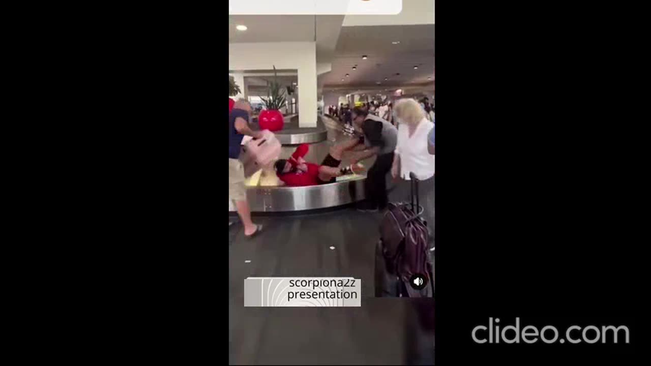 A passenger slips while taking his luggage from the baggage counter at the airport...