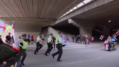 Mean while in England： Six cops chasing a disabled man in an electric wheelchair.