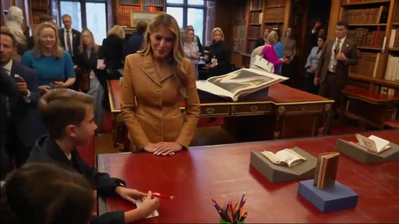 First Lady Melania Trump speaks with children in the Royal Library at Windsor Castle this morning