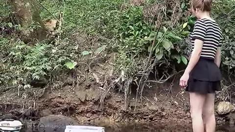 A beautiful lady catching fish from pool