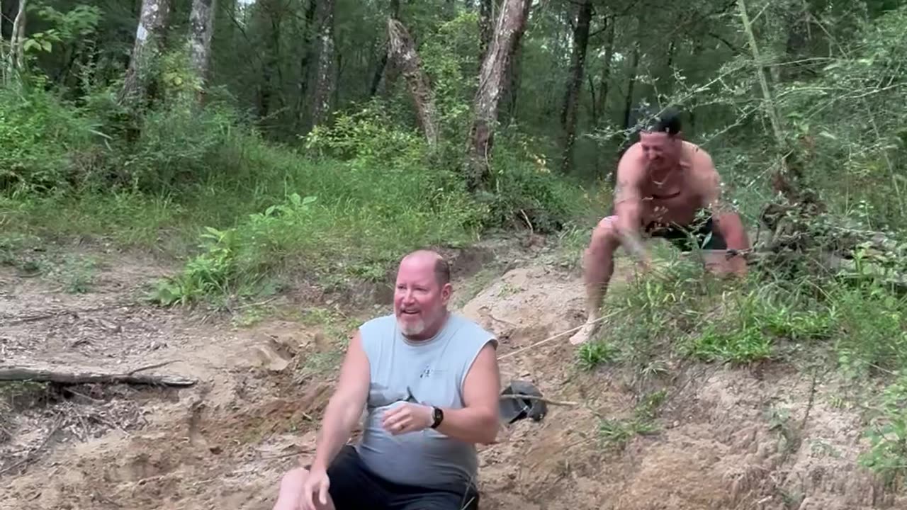 Dad and Stepson Laughing and Slipping on a Sandy Hill