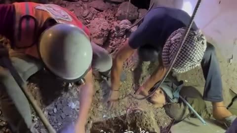 Rescue teams save a girl from under the rubble of the Al-Darwish family home in the Nuseirat Camp