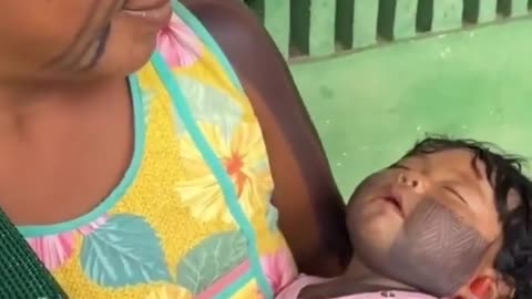 The markings on the baby's face & arm are traditional Jagua dye not tattoos. They fade over time.