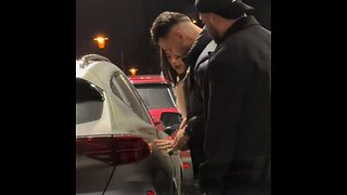 Tres personas luchan por cerrar una tapa de combustible en una gasolinera