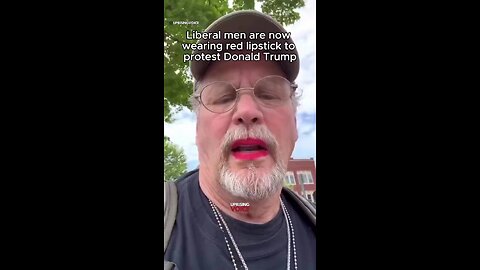 A liberal man applies red lipstick as a protest against Trump.