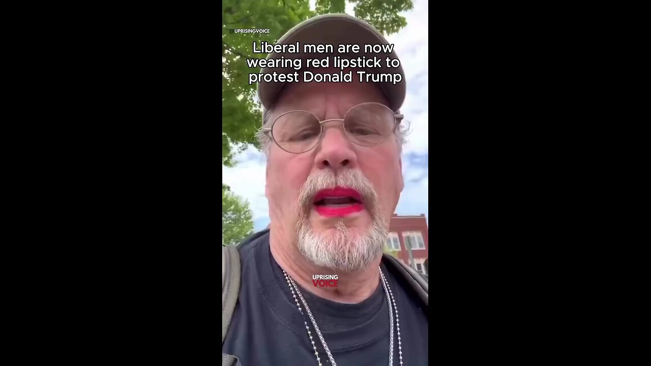 A liberal man applies red lipstick as a protest against Trump.