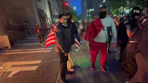 A man saves an American flag after a Mexican nationalist attempted to throw it into a burning dump