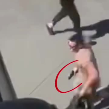 Is this man running with a hand gun??