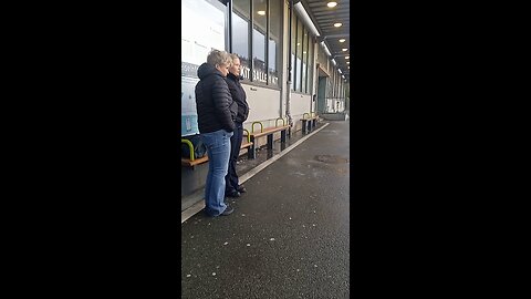 Mom and daughter in a short jacket freezing while waiting for the bus.