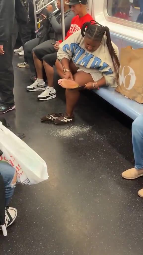 Woman files off dead skin from her feet on public subway