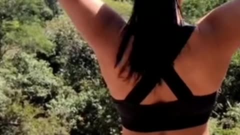 Peaceful Yoga by the Stream: Beautiful Girl Relaxing in a Rainforest Paradise