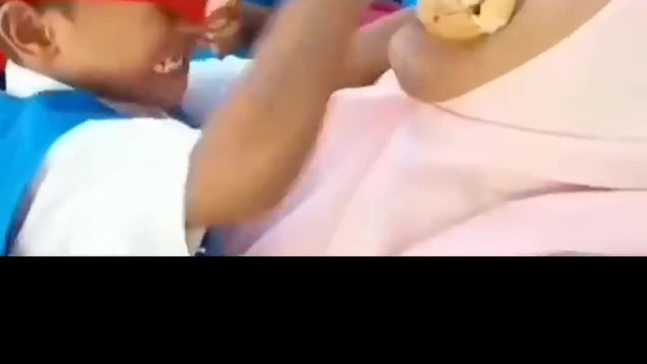 A student is putting bread into his teacher's mouth