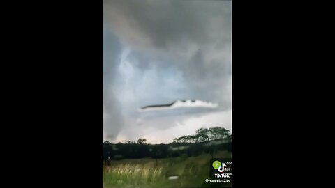 Cloaked UFO appears next to a tornado while the weatherman tries to obscure the area.