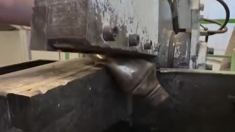 Hydraulic shear machine crushing catalytic converters, a process used to extract valuable metals like platinum, palladium, and rhodium 