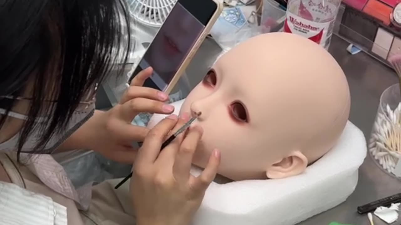 Schminken Sie die Puppe.