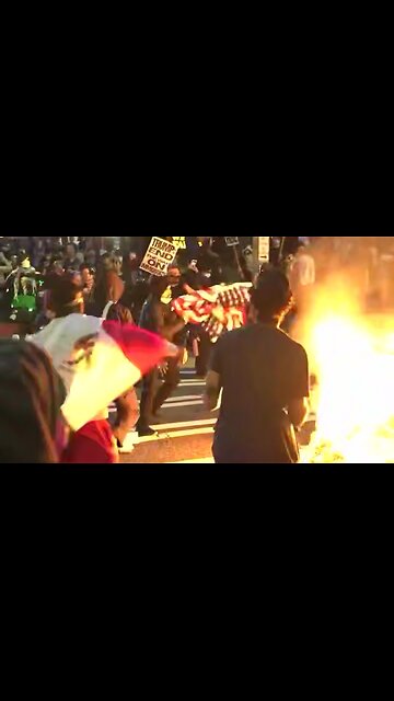A young Latino male stops protestor from burning the American flag
