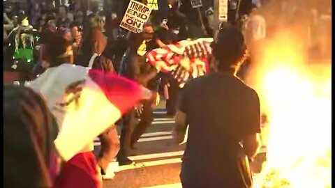 A young Latino male stops protestor from burning the American flag