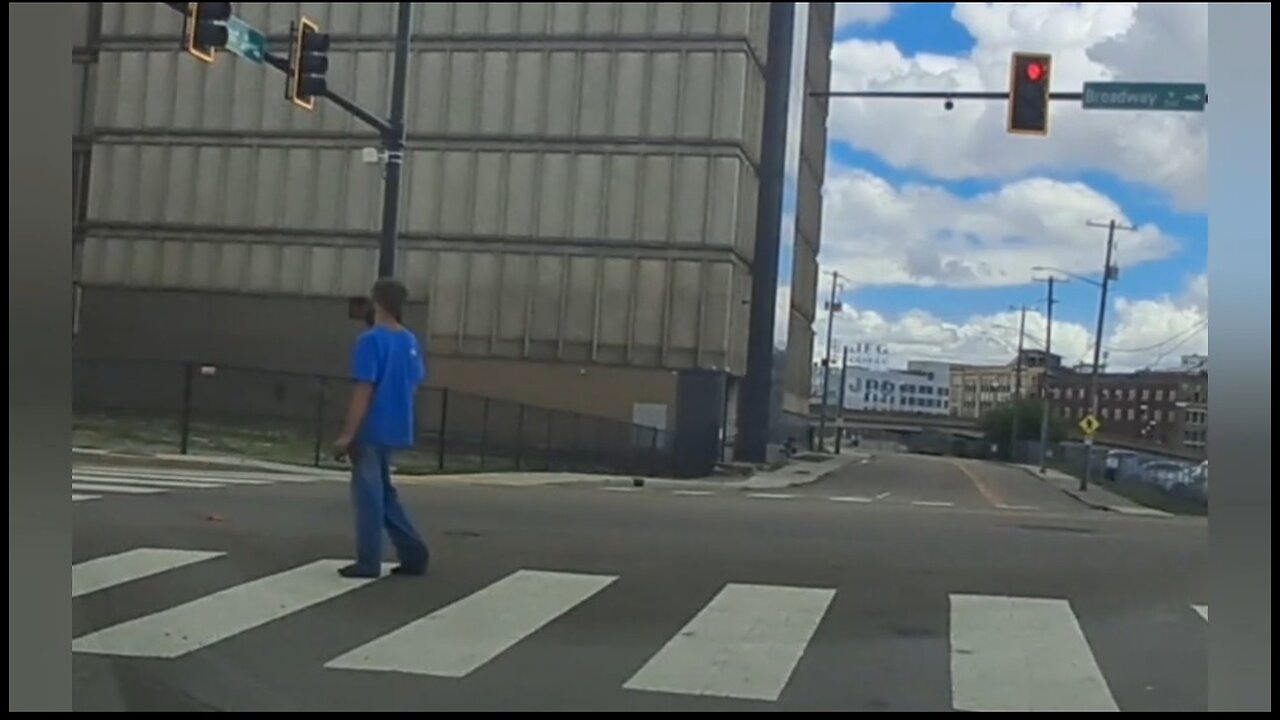 Catatonic homeless man frozen motionless in middle of busy intersection