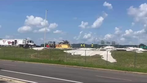 18 wheeler turns over carrying a load of drywall.
