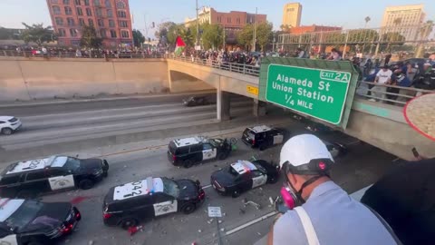 Police cruisers pelted by large rocks as officers take shelter in the underpass in Los Angeles