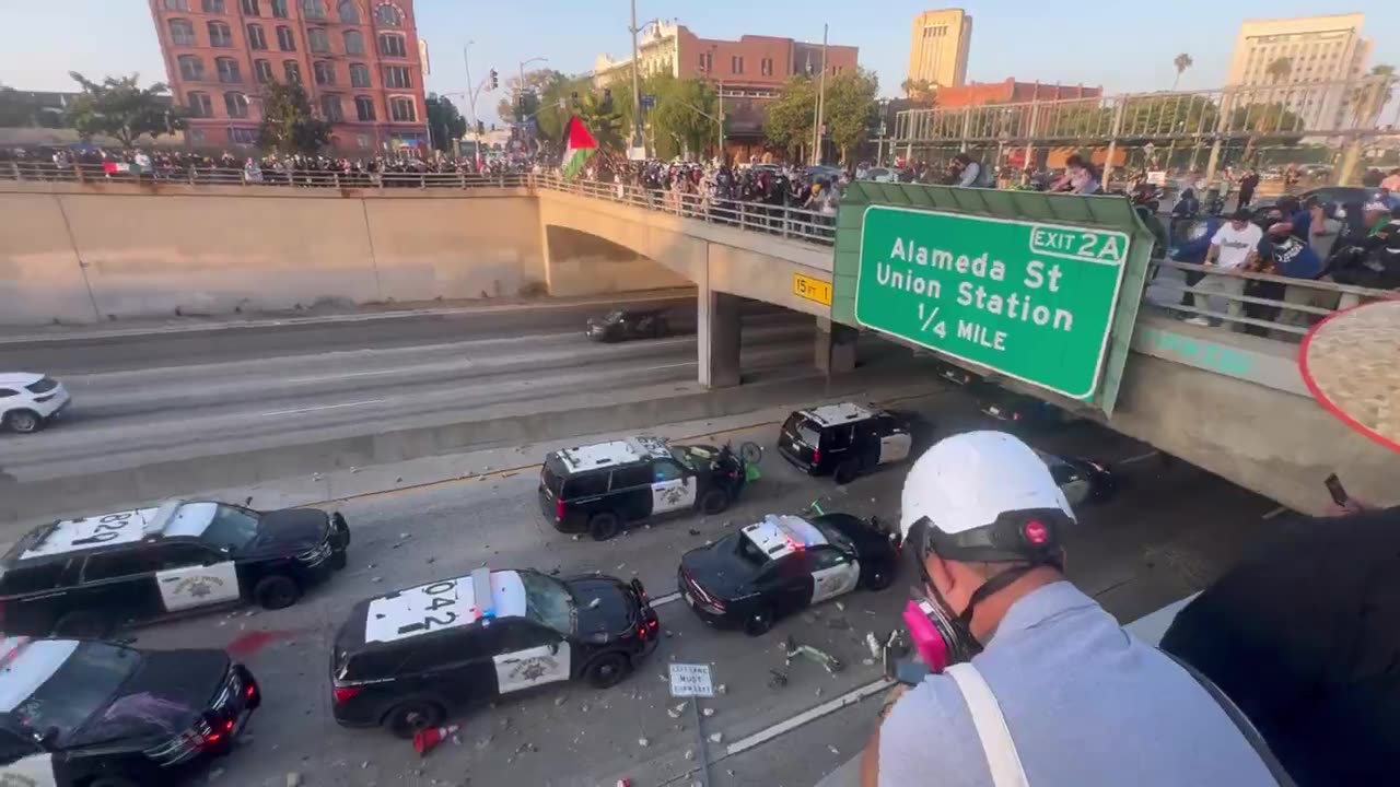 Police cruisers pelted by large rocks as officers take shelter in the underpass in Los Angeles