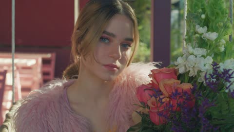 Portrait of a blonde woman while smelling a bouquet of flowers during a date on Valentine's Day.
