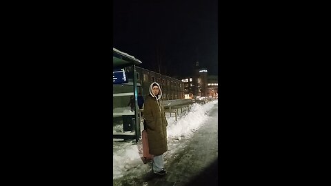 Beautiful girl freezing in the northern frost of -7°C and wind, waiting for the bus.