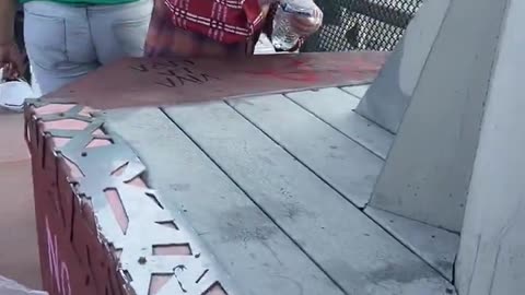 Amidst the chaos an elderly citizen is doing her best to clean up