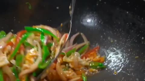 Stir fry sausages eggs and green pepper cooking