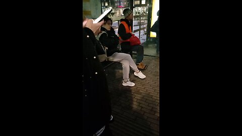 Beautiful woman in a light jacket freezes while waiting for the bus.