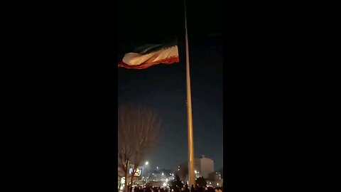 The protesters are taking down and tearing apart a huge Iranian flag in the city of Mashhad