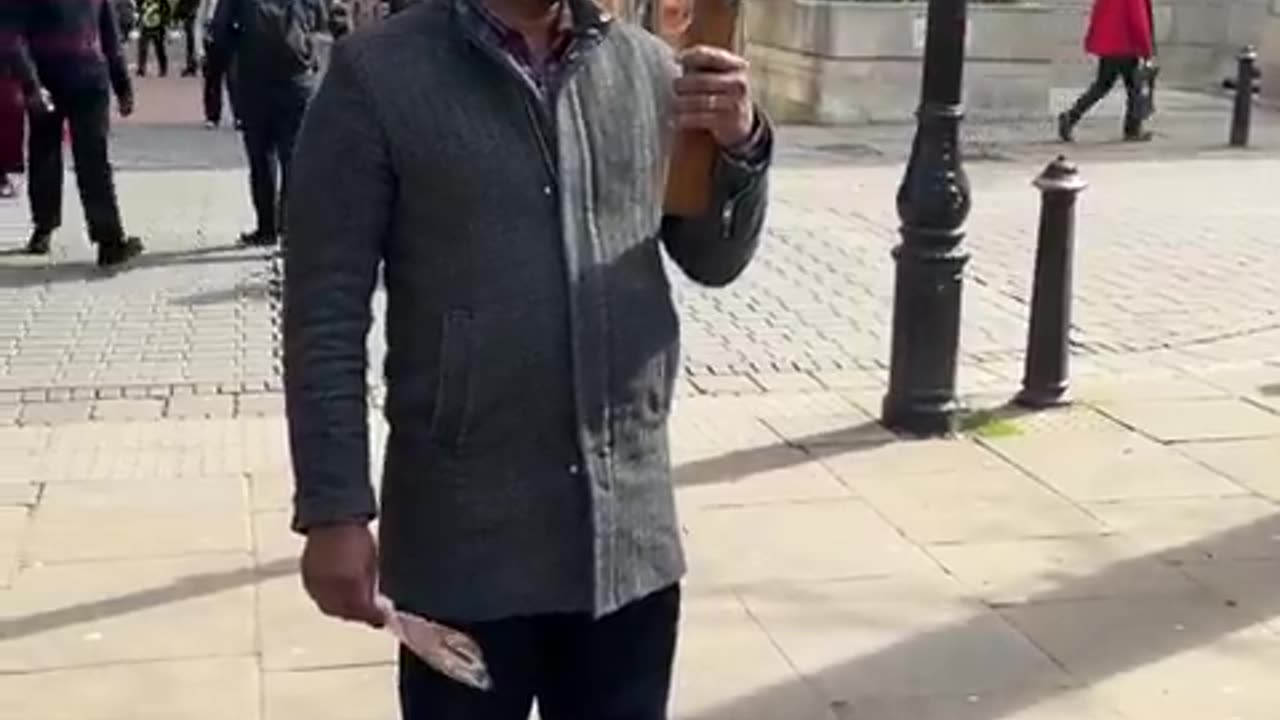 A Catholic preaches Jesus displaying a crucifix in a busy street in Birmingham