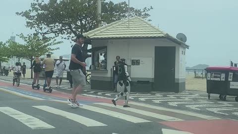 Man Pilots Walking Robot Across Pedestrian Crossing