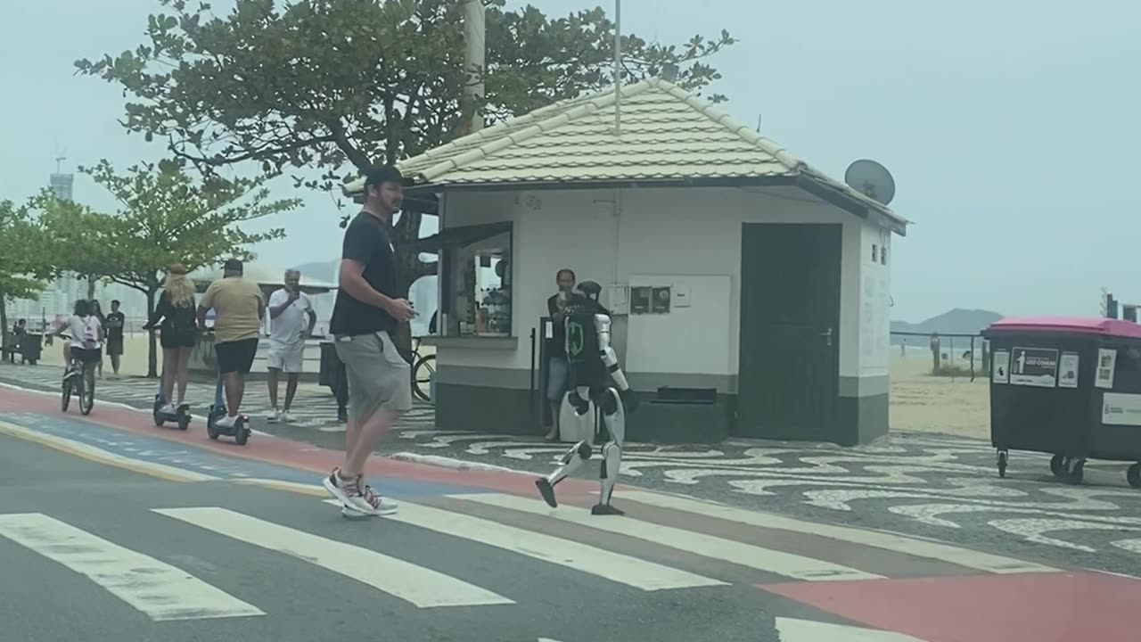 Man Pilots Walking Robot Across Pedestrian Crossing