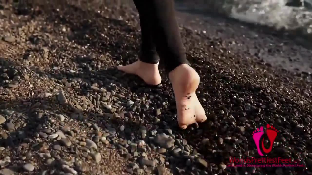 female feet walking along a rocky shoreline walking barefoot walking in slow motion dirty feet