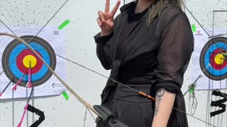 🌑🏹 Cloaked in gothic grace, she draws her recurve bow.