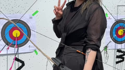 🌑🏹 Cloaked in gothic grace, she draws her recurve bow.