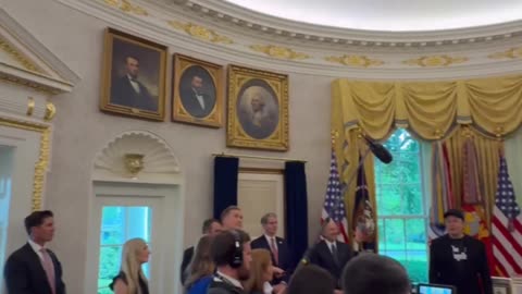 President Trump was seated behind the Resolute Desk. Elon Musk was standing next to him