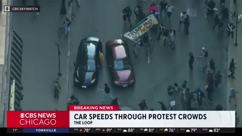 Pissed off motorist drives through the anti-ICE mob blocking off traffic in Chicago