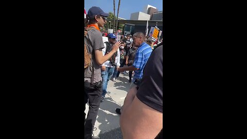 Clashes between a man and a protester holding an American flag in DTLA.
